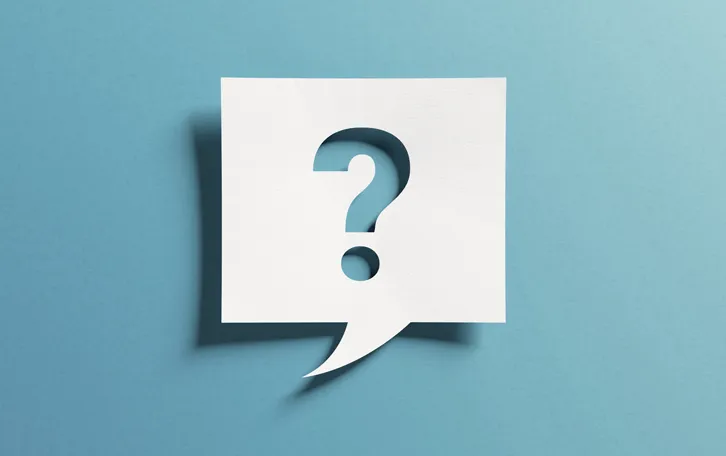 Notizzettel mit Schatten als Sprechblase mit einem Fragezeichen ausgeschnitten vor blauem Hintergrund