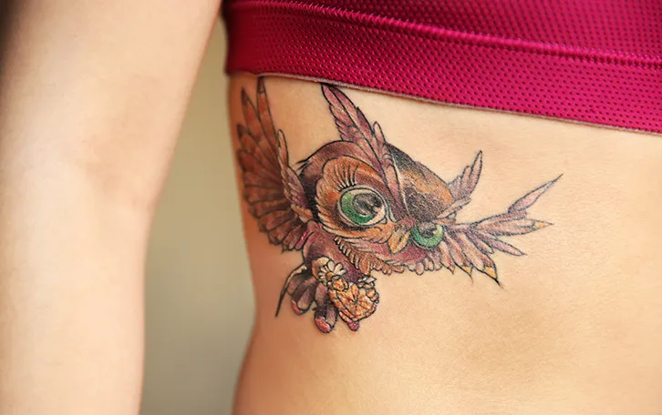 schmerzhaftesten-zonen-bei-taetowierungen-rippen Eulentattoo im rechten Rippenbereich